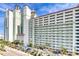 Large building exterior with multiple stories, balconies, and a parking area, showcasing resort living at 3000 N Ocean Blvd. N # 129, Myrtle Beach, SC 29577