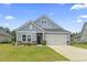 Charming single-story home with blue siding, a manicured lawn and attached two-car garage at 3021 Sistine St., Myrtle Beach, SC 29579
