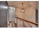 Staircase hallway with gray accent wall, wooden bannister, and modern light fixture at 3120 Mercer Dr., Conway, SC 29526