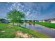 Scenic pond with a fountain, surrounded by lush green grass and charming homes in the background at 3120 Mercer Dr., Conway, SC 29526