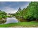 Scenic water view showing a pond and a house in the distance surrounded by trees at 3120 Mercer Dr., Conway, SC 29526