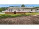 View of backyard featuring a brick foundation, white deck and siding, and a green lawn at 3808 Mayfield Dr., Conway, SC 29526