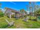 Large backyard featuring a deck, patio, fireplace, and beautifully landscaped lawn at 3827 El Duce Pl., Myrtle Beach, SC 29588