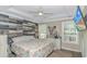 Spacious main bedroom featuring wood accent wall, a ceiling fan, and plenty of natural light at 3827 El Duce Pl., Myrtle Beach, SC 29588