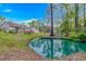 Expansive backyard features a tranquil pond with fountain, mature trees, and lush greenery at 3827 El Duce Pl., Myrtle Beach, SC 29588