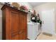 Organized laundry room with front load washer, dryer, wood cabinet and shelving for storage and efficient functionality at 388 Hillsborough Dr., Conway, SC 29526