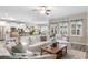 Open-concept living space with white sofas, a wooden coffee table, and views of the modern kitchen at 388 Hillsborough Dr., Conway, SC 29526