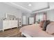 Bright main bedroom showcasing a dresser, a makeup vanity, plush pillows, and hardwood floors at 388 Hillsborough Dr., Conway, SC 29526
