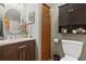 Bathroom boasts a wood vanity with marble countertops, round mirror, storage cabinet, and wood-slatted closet for a cozy design at 390 Boundary Ave., Murrells Inlet, SC 29576