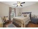Cozy bedroom features a queen-size bed, wood floors, decorative pillows, and a fan with light for a relaxing and inviting ambiance at 390 Boundary Ave., Murrells Inlet, SC 29576