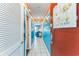 Hallway leading to the unit's living space with beach themed decor, tile flooring, and access to various rooms at 415 Ocean Creek Dr. # 2330, Myrtle Beach, SC 29572