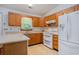 Traditional kitchen featuring wood cabinetry, white appliances, and functional layout at 4311 Bradford Circle, Myrtle Beach, SC 29588