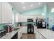 Well-lit kitchen featuring white cabinets, granite countertops, and modern appliances at 4338 Grande Harbour Blvd., Little River, SC 29566