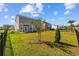 Spacious backyard with a young tree, grassy area, fence, and view of the home's exterior at 4410 Honir Dr., Myrtle Beach, SC 29579