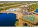 Aerial view of the community with a pool area, tennis court, and a picturesque lake view at 4410 Honir Dr., Myrtle Beach, SC 29579