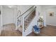 Inviting foyer showcasing hardwood floors, a staircase with decorative iron spindles, and neutral décor at 4410 Honir Dr., Myrtle Beach, SC 29579