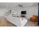 Bright living room featuring a white sofa, fireplace, wood floors, and stairway at 4410 Honir Dr., Myrtle Beach, SC 29579