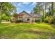 Lush backyard featuring a well-manicured lawn, patio area, and mature trees, creating a serene outdoor space at 444 Dornoch Dr., Pawleys Island, SC 29585
