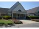Charming clubhouse entrance adorned with landscaping, bushes, and a covered entryway at 444 Dornoch Dr., Pawleys Island, SC 29585