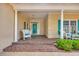 Inviting front porch with white wicker furniture and a vibrant turquoise front door at 444 Dornoch Dr., Pawleys Island, SC 29585