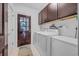 Functional laundry room with cabinets, washer, dryer, and an exterior door for easy access at 444 Dornoch Dr., Pawleys Island, SC 29585