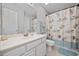 Bathroom with white vanity, large mirror, and seashell shower curtain, providing a clean, beachy ambiance at 4506 West Harbor Ct. # U-15, Little River, SC 29566