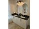 Bathroom featuring dual sinks, white cabinets, and sleek black countertops at 451 W Palm Dr., Myrtle Beach, SC 29579