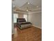 Spacious main bedroom showcasing tray ceiling, a decorative bed, and hardwood floors at 451 W Palm Dr., Myrtle Beach, SC 29579