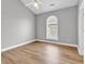 Bright bedroom featuring wood-look flooring, a ceiling fan, and a arched window at 4705 Wild Iris Dr. # 305, Myrtle Beach, SC 29577