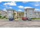 Beautiful multi-story condo building with stone accents and manicured landscaping, located next to parking area at 4705 Wild Iris Dr. # 305, Myrtle Beach, SC 29577