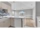 Stylish kitchen with white cabinets, quartz countertops and mosaic backsplash opening to dining area at 4705 Wild Iris Dr. # 305, Myrtle Beach, SC 29577