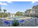 Community pool surrounded by lounge chairs and palm trees at 4705 Wild Iris Dr. # 305, Myrtle Beach, SC 29577