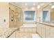 Bathroom featuring a soaking tub, glass shower, granite countertops, and natural stone flooring at 509 Heston Point Dr., Pawleys Island, SC 29585