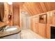 Cozy bathroom with wooden paneled walls, granite countertop, and a corner glass shower at 509 Heston Point Dr., Pawleys Island, SC 29585