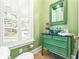 Powder room with an emerald green vanity, vessel sink and patterned mirror, and a bright window at 509 Heston Point Dr., Pawleys Island, SC 29585