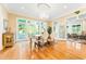 Bright dining room featuring hardwood floors, a chandelier, and multiple windows and doors to the exterior at 509 Heston Point Dr., Pawleys Island, SC 29585