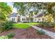 Stately two-story home with stone accents, lush landscaping, and a grand entryway framed by a mature oak tree at 509 Heston Point Dr., Pawleys Island, SC 29585