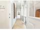Inviting hallway with tiled flooring and light gray siding, leading to a white-framed glass door at 509 Heston Point Dr., Pawleys Island, SC 29585