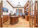 Home office with wood-paneled walls, hardwood floors, custom bookshelves, and ample workspace at 509 Heston Point Dr., Pawleys Island, SC 29585