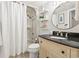 Bright bathroom featuring a vanity with black countertop, decorative shelves and shower with curtain at 5523 North Ocean Blvd. # 1903, Myrtle Beach, SC 29577