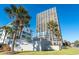 Ocean Forest Plaza condo building exterior featuring palm trees and lush landscaping on a bright, sunny day at 5523 North Ocean Blvd. # 1903, Myrtle Beach, SC 29577