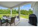 Covered back porch featuring outdoor dining area and serene wooded views at 5605 Whitebark Dr., Myrtle Beach, SC 29577