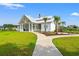 Beautiful new clubhouse with covered porch, landscaping, and walkway surrounded by green grass at 5605 Whitebark Dr., Myrtle Beach, SC 29577