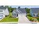 Aerial view of charming home with a two-car garage, covered porch, manicured lawn, and gray board and batten siding at 5605 Whitebark Dr., Myrtle Beach, SC 29577