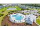 Aerial view of community pool featuring lounge chairs, umbrellas, nearby pond, and neighborhood at 5605 Whitebark Dr., Myrtle Beach, SC 29577