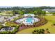 Aerial view of community pool featuring lounge chairs, umbrellas, playground, and nearby pond at 5605 Whitebark Dr., Myrtle Beach, SC 29577