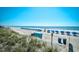 Scenic view of the beach featuring blue umbrellas and ocean waves on a clear sunny day at 5905 South Kings Hwy. # 116B, Myrtle Beach, SC 29575