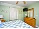 This well-lit bedroom is furnished with a queen bed, a dresser, and a mounted flat-screen TV at 5905 South Kings Hwy. # 116B, Myrtle Beach, SC 29575