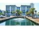 Beautiful waterfront condo complex with palm trees and a fountain in the foreground, offering serene views and coastal charm at 5905 South Kings Hwy. # 116B, Myrtle Beach, SC 29575