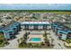 Aerial view of condominium community and pool with lush green landscaping and parking, near waterway at 6000 N Ocean Blvd. # 119, North Myrtle Beach, SC 29582